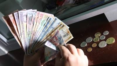 Un cajero bancario cuenta dinero en lempiras.