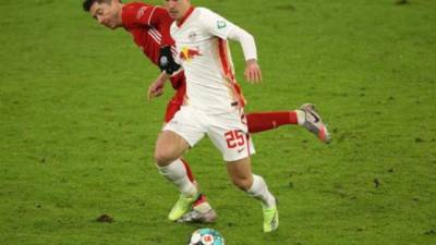 Dani Olmo de RB Leipzig es desafiado por Robert Lewandowski del FC Bayern Munich durante el partido de fútbol de la Bundesliga alemana.