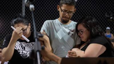 Tres empleados del Walmart donde ocurrió el tiroteo lloran durante una vigilia en El Paso./AFP.