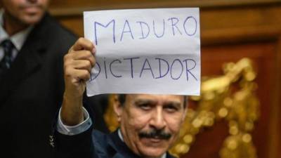 Un diputado opositor mostró un cartel que acusa de dictador al presidente Maduro.