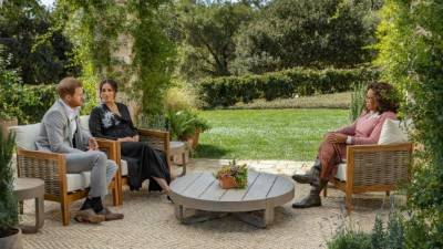 This undated image released March 7, 2021 courtesy of Harpo Productions shows Britain's Prince Harry (L) and his wife Meghan (C), Duchess of Sussex, in a conversation with US television host Oprah Winfrey. - Britain's royal family on March 7, 2021 braced for further revelations from Prince Harry and his American wife, Meghan, as a week of transatlantic claim and counter-claim reaches a climax with the broadcast of their interview with Oprah Winfrey. The two-hour interview with the US TV queen is the biggest royal tell-all since Harry's mother princess Diana detailed her crumbling marriage to his father Prince Charles in 1995. (Photo by Joe PUGLIESE / HARPO PRODUCTIONS / AFP) / RESTRICTED TO EDITORIAL USE - MANDATORY CREDIT 'AFP PHOTO/ HARPO PRODUCTIONS - Joe PUGLIESE' - NO MARKETING NO ADVERTISING CAMPAIGNS - DISTRIBUTED AS A SERVICE TO CLIENTS --- NO ARCHIVE ---