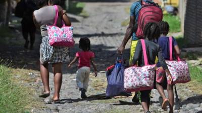 Una familia de migrantes haitianos camina hacia la oficina de migraciones en Choluteca, Honduras, el pasado 16 de noviembre de 2019, después de pasar por un cruce ciego entre Nicaragua y Honduras en su camino a los Estados Unidos.