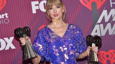 Taylor Swift posa con sus premios a mejor tour del año y mejor video musical en los iHeart Radio Music Awards este marzo 14 de 2019 i. Foto Chris Delmas / AFP.