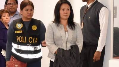 Handout picture distributed by Peruvian Judiciary showing Keiko Fujimori, opposition leader and daughter of disgraced ex-president Alberto Fujimori, being escorted by police officers in a Judiciary office, in Lima, following her arrest on October 10, 2018, for alleged money laundering involving Brazilian construction giant Odebrecht. - The 43-year-old was arrested on the orders of prosecutors investigating contributions to her campaign when she ran for president in 2011, her lawyer Giuliana Loza said. (Photo by Juan Carlos VIVAS / Peruvian Judiciary / AFP) / RESTRICTED TO EDITORIAL USE - MANDATORY CREDIT 'AFP PHOTO / PERUVIAN JUDICIARY-JUAN CARLOS VIVAS' - NO MARKETING - NO ADVERTISING CAMPAIGNS - DISTRIBUTED AS A SERVICE TO CLIENTS