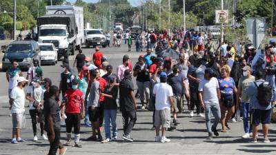 Un grupo de migrantes centroamericanos y haitianos, bloquean una vialidad este miércoles, en el municipio de Tapachula en el estado de Chiapas.