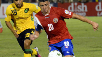 El jugador costarricense Diego Calvo es marcado por el jamaicano Adrian Mariappa.