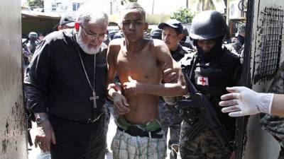 Monseñor Rómulo Emiliani en el momento en que auxilia a uno de los reclusos.