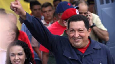 Accompanied by his daughter Rosa Virginia, left, Venezuela's President Hugo Chavez gestures to supporters as he leaves the polling station after voting in the presidential election in Caracas, Venezuela, Sunday, Oct. 7, 2012. Chavez is running for re-election against opposition candidate Henrique Capriles. (AP Photo/Rodrigo Abd)