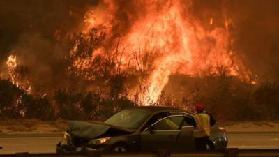 EUA. Evacuados más de 200,000 por incendios. Una mujer recibe auxilio en una autopista de Ventura, California, donde el incendio amenaza a unas 12,000 casas. El sur del estado en devastación.
