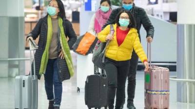 Los pasajeros de vuelos usan máscaras faciales en el check-in de la aerolínea china Air China el 30 de enero de 2020 en el aeropuerto de Frankfurt am Main, en el oeste de Alemania. La aerolínea insignia de Alemania, Lufthansa, dijo el 29 de enero de 2020 que cancelaría todos los vuelos a China continental hasta el 9 de febrero de 2020, a medida que aumentan los temores sobre el mortal coronavirus. AFP.