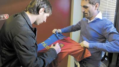 Barcelona's Argentinian forward Lionel Messi (L) signs autographs after a press conference at the Ciutat esportiva Joan Gamper near Barcelona on December 1, 2009. Lionel Messi has been named European Footballer of the Year and won the prestigious Ballon d'Or award. AFP PHOTO/LLUIS GENE.