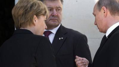 La canciller alemana Angela Merkel, el presidente electo de Ucrania Petro Poroshenko y el ruso Vladimir Putin dialogan en Bénouville, Francia.