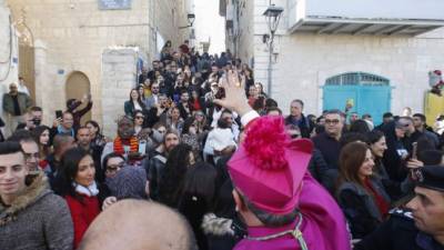 Apostolic Administrator of the Latin Patriarchate of Jerusalem Pierbattista Pizzaballa (C) is greeted by a crowd upon his arrival to the biblical West Bank city of Bethlehem on December 24, 2019. - Pizzaballa will lead the annual Christmas eve procession at the Church of the Nativity. (Photo by HAZEM BADER / AFP)