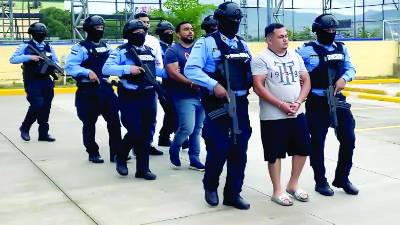 Elementos policiales custodian a la banda de secuestradores que operó en la capital hondureña.
