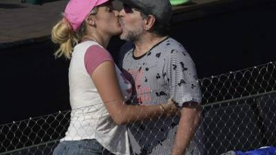 (FILES) This file photo taken on February 03, 2017 shows Argentine football legend Diego Maradona (R) and his girlfriend Rocio Oliva kiss during the 2017 Davis Cup World Group first round single tennis match between Italy's tennis player Andreas Seppi and Argentine player Carlos Berlocq at Parque Sarmiento stadium in Buenos Aires on February 3, 2017. Seppi won 6-1, 6-2, 1-6, 7-6 (8-6).Spanish police were called to a Madrid hotel by concerned staff on Februrary 15, 2017 over an argument between former Argentine footballer Diego Maradona and his girlfriend. 'When the agents and emergency services arrived, those people (Maradona and his girlfriend) showed no sign of injuries and did not press charges, there was just a discussion,' police sources told AFP. / AFP PHOTO / JUAN MABROMATA