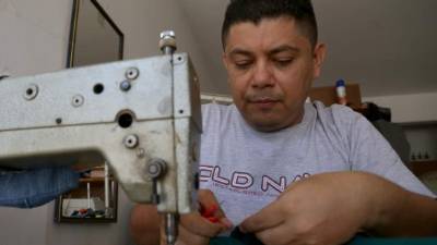 Selvin Serrano costura una prenda de vestir en su taller ubicado en el barrio guamilito. Fotos: Yoseph Amaya