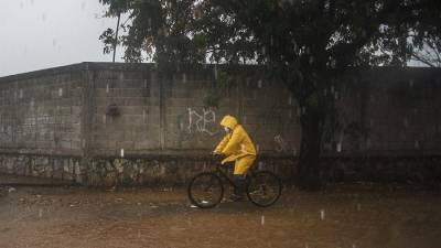 Personas transitan por una avenida inundada en el municipio de Tehuantepec, estado de Oaxaca (México).