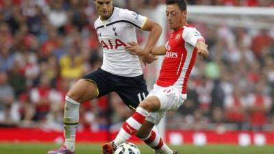 Mesut Özil disputa el balón con Erik Lamela.