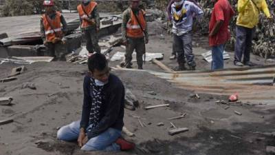 Bryan Rivera, 22, llora sobre su casa, donde quedó sepultada casi toda su familia tras la erupción del volcán de Fuego./AFP.