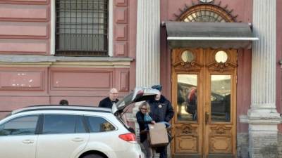 Una mujer empaca algunas cosas en un un vehículo estacionado frente al consulado de Estados Unidos en San Petersburgo, Rusia, el cual debe quedar cerrado para el sábado por orden del gobierno ruso.