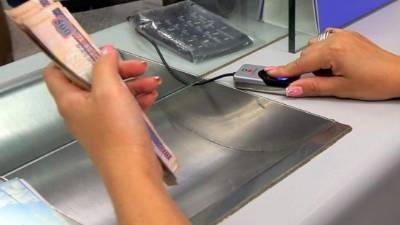 Una cajera cuenta billetes de dólar.