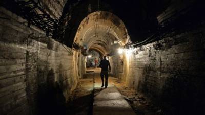 Hombres caminan donde el 'tren del oro nazi' está supuestamente escondido bajo tierra.