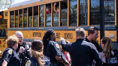 Policías evacuan a un grupo de niños tras el tiroteo en una escuela primaria cristiana de Nashville.