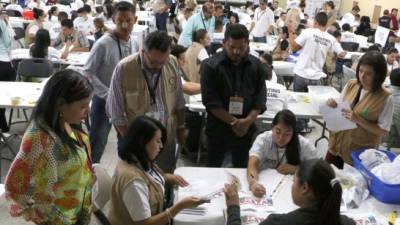 Personal del TSE trabaja contando los votos de las elecciones en Honduras siempre con la presencia de los observadores de la OEA.
