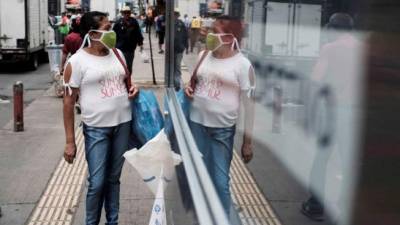 Una mujer con mascarilla es vista mientras camina por una calle de San José, (Costa Rica). EFE/Jeffrey Arguedas/Archivo