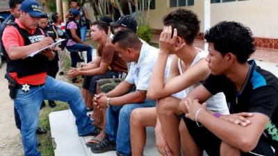 Los detenidos cuando eran chequeados por un agente de la Policía de El Progreso.