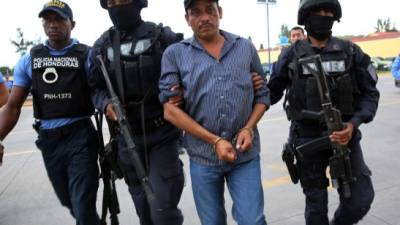 Agentes de la Policía Nacional custodian al regidor nacionalista José Castillo luego de ser trasladado ayer de El Triunfo, Choluteca, a la DPI en Tegucigalpa.