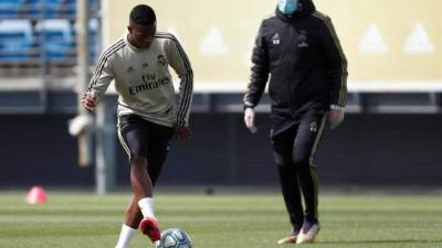 El delantero brasileño del Real Madrid Vinicius Jr. (i) junto a su entrenador, el francés Zinedine Zidane, durante el entrenamiento practicado este lunes en Valdebebas, en Madrid. EFE/LaLiga