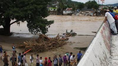 Habitantes cruzan un puente colapsado hoy, miércoles 18 de septiembre de 2013, en Coyuca de Benítez, estado de Guerrero (México).
