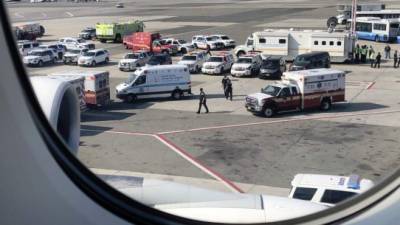 Equipos de los Centros para el Control y la Prevención de Enfermedades atendieron a los pasajeros enfermos en la pista del JFK./Twitter: Larry Coben.