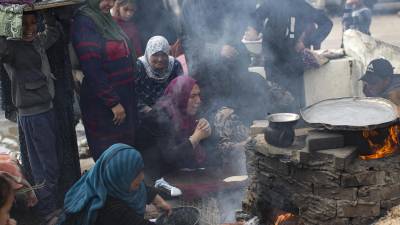 Familias palestinas desplazadas hacen pan en un horno de leña debido a la ausencia de gas en un campo de refugiados en Rafah, en las Franja de Gaza, este sábado. EFE/ Haitham Imad