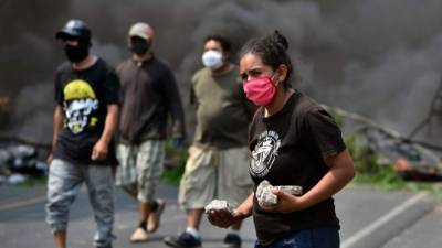 Una mujer participa en una protesta contra el entierro de personas que murieron por el coronavirus. AFP