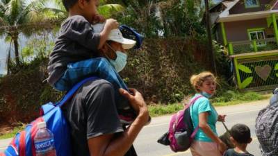 Un joven padre carga a su hijo en los hombros durante su travesía hacia EUA. foto: Amílcar Izaguirre.