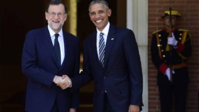 Spanish Prime Minister Mariano Rajoy (L) shakes hand with US president Barack Obama at Moncloa palace in Madrid on July 10, 2016.Obama said he will cut short a foreign trip and visit Dallas next week as the shooting rampage by the black army veteran, who said he wanted to kill white cops, triggered urgent calls to mend troubled race relations in the United States. / AFP PHOTO / PIERRE-PHILIPPE MARCOU