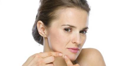 Beauty portrait of young woman squeezing acne