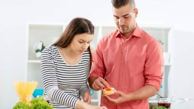 Charming couple, between 20-25 years old, in modern casual clothing, preparing delicious dinner with lots of vegetables, cheese, ham and eggs, while sipping red wine. Image taken with Nikon D800 and professional Nikon lens, developed from RAW in XXXL size. Location: Novi Sad, Serbia, Central Europe, Europe