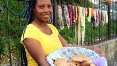 Una mujer vende pan de coco.