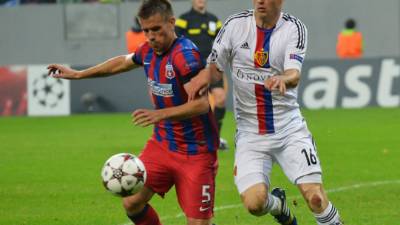 Mihai Pintilii del Steaua de Bucarest es marcado por Fabian Schar del Basilea.