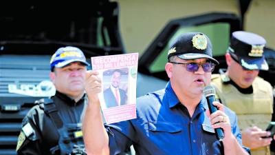<b>El ministro Héctor Sánchez muestra un afiche en el que la Secretaría de Seguridad ofrece L350,000 de recompensa.</b>
