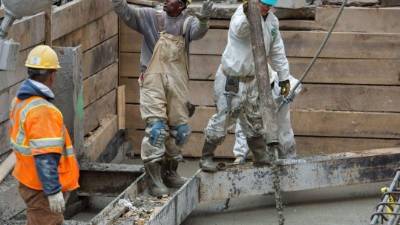 Trabajadores de la construcción vierten hormigón para hacer los cimientos de un nuevo edificio en Washington.
