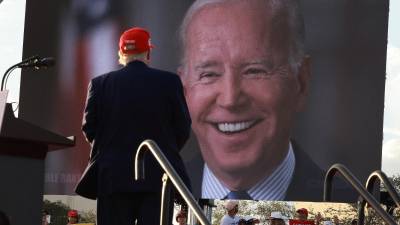 Trump observa un video de campaña de Biden durante un mitin en Florida previo a las elecciones legislativas de este martes.