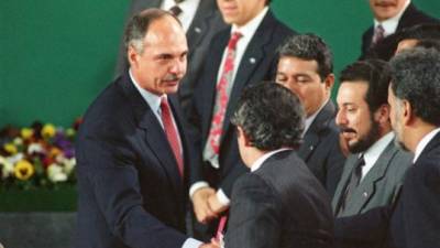El presidente Alfredo Cristiani saluda con un apretón de manos a los representantes de la guerrilla durante la ceremonia de la firma del acuerdo de paz el 16 de enero de 1992.