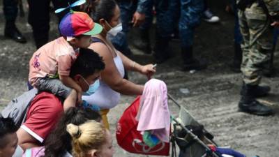 Los migrantes hondureños rompen la valla policial para ingresar a Guatemala en su camino a los Estados Unidos, en la frontera de Corinto, Hondura. AFP