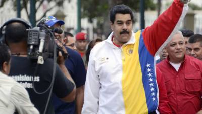 El presidente venezolano, Nicolás Maduro (d), acompañado del candidato oficialista a la Alcaldía del municipio metropolitano Libertador, Jorge Rodríguez, saluda hoy, domingo 8 de diciembre de 2013, durante las elecciones municipales, en Caracas (Venezuela). Maduro llamó a los candidatos a las elecciones municipales de este domingo a aceptar los resultados 'en paz' y afirmó que ha tomado 'todas las medidas' para neutralizar supuestas 'loqueras' (locuras) destinadas a conspirar contra el proceso electoral. EFE