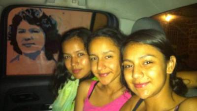 Las hijas de la ambientalista asesinada Berta Cáceres. Al fondo el rostro de la líder indígena.