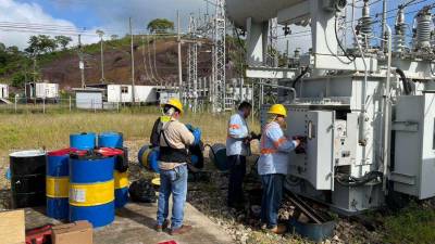 Técnicos de la Enee reparan un transformador de energía. archivo.
